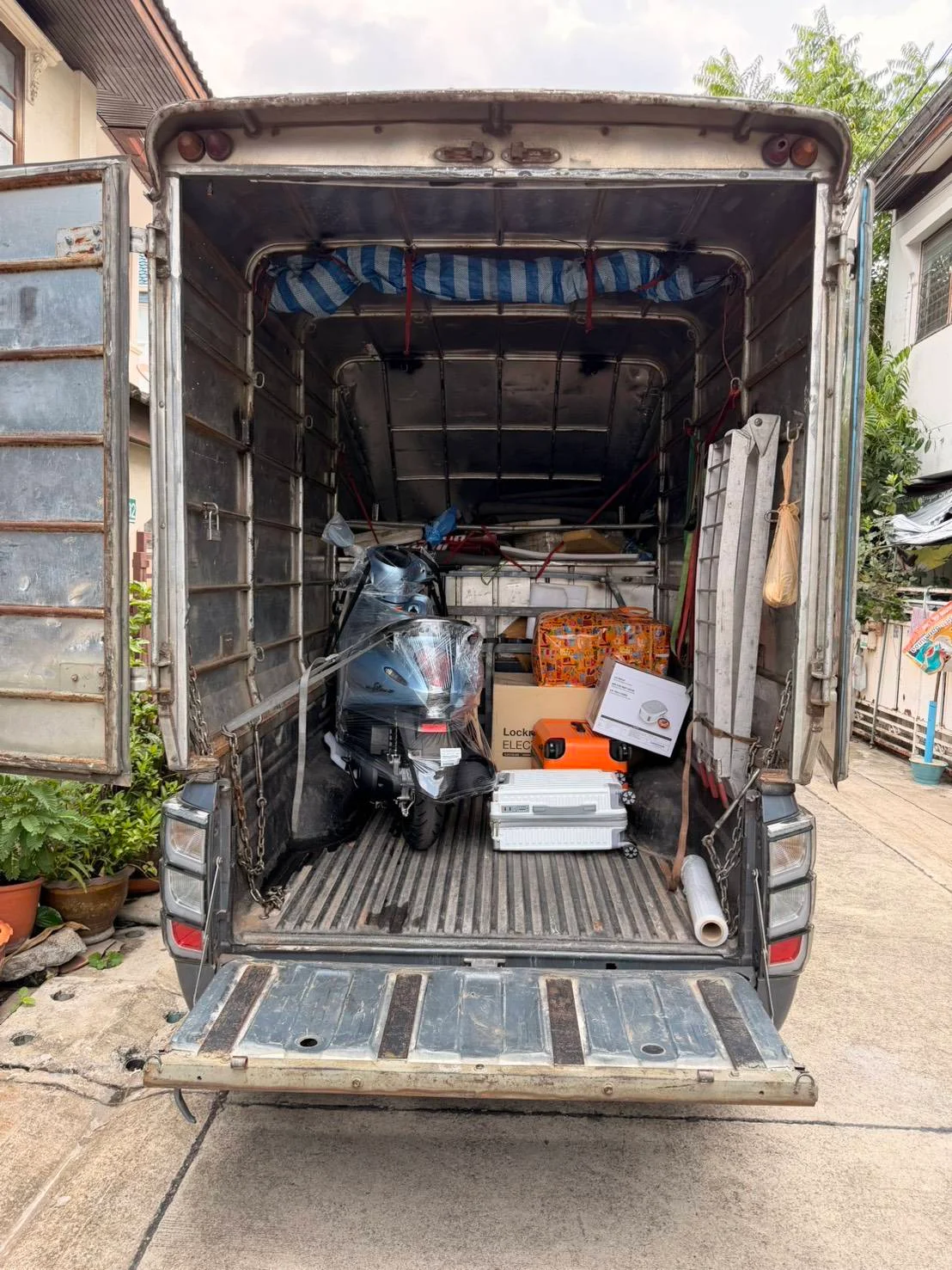 งานขนย้ายห้องพักที่มีทั้งกล่องสัมภาระ กระเป๋าเดินทาง และรถมอเตอร์ไซค์ในเที่ยวเดียว